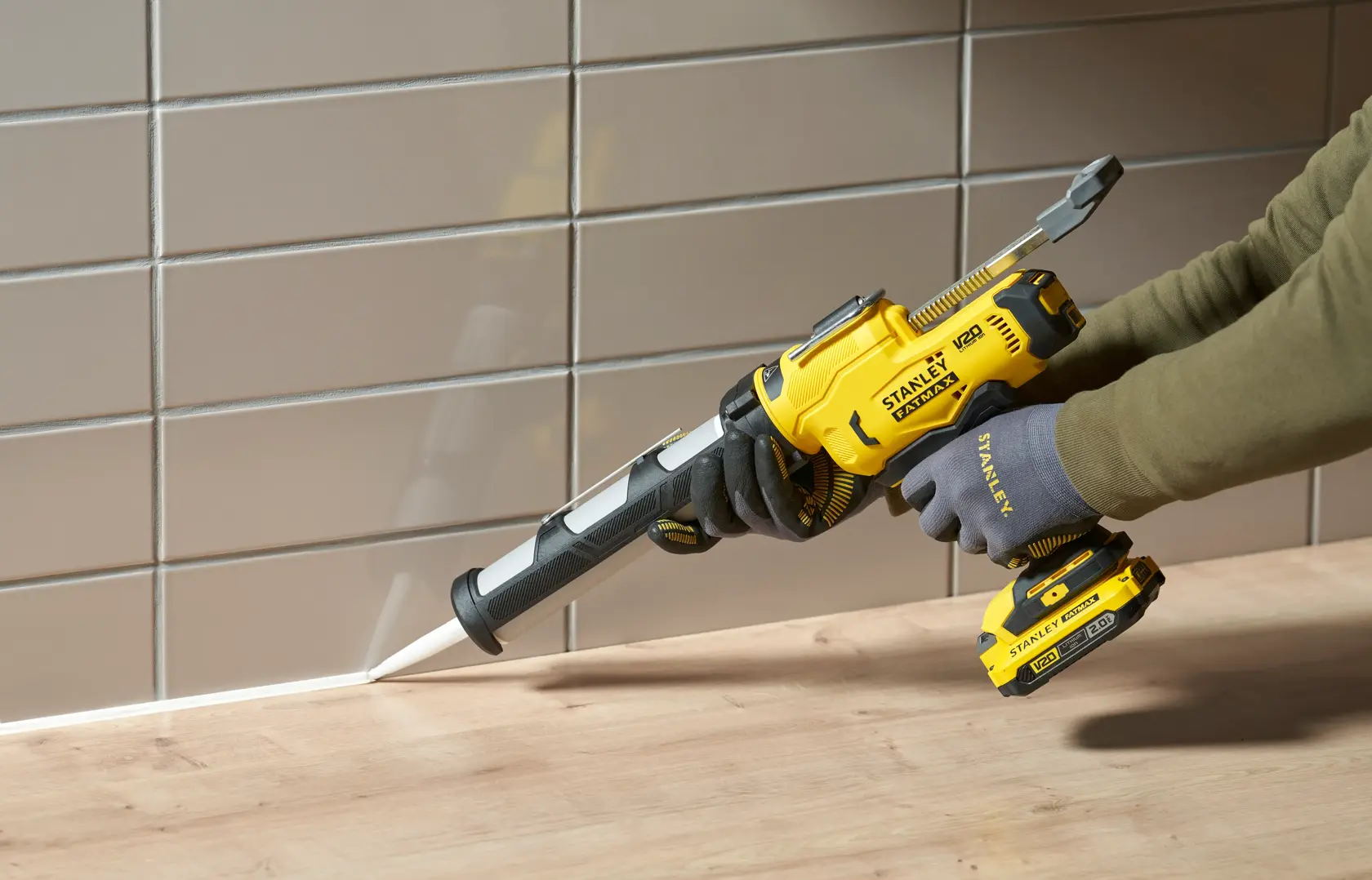 STANLEY SFMCE600B kabellose Kartuschenpresse beim Abdichten einer Fuge zwischen Holzarbeitsplatte und Fliesenwand.