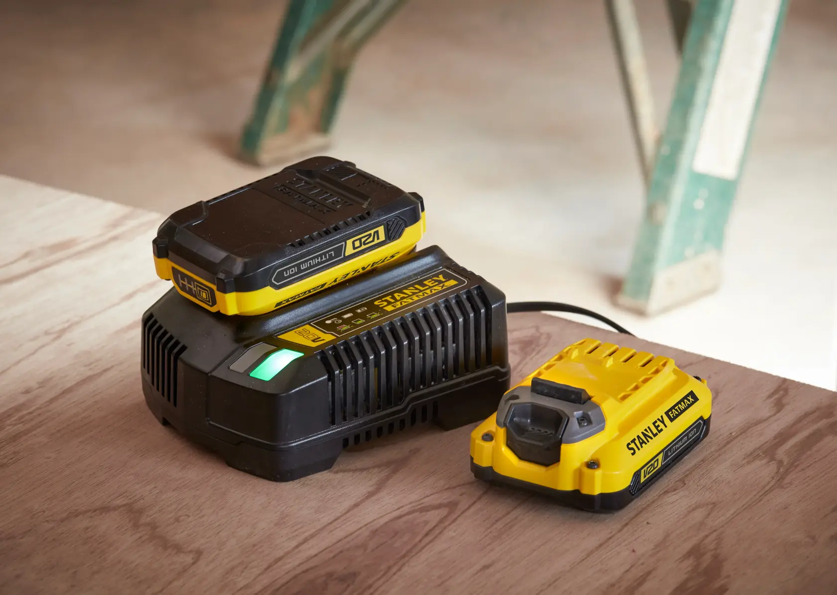 STANLEY SFMCF800C2K photography of yellow and black battery charger and battery on wood surface