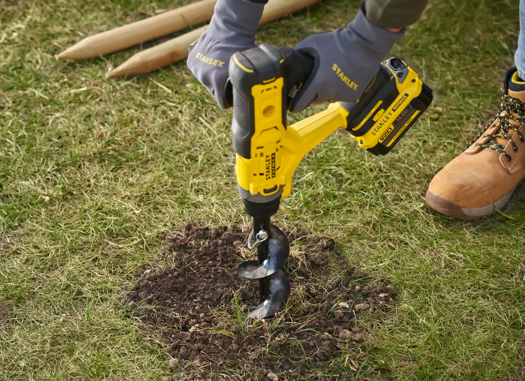 STANLEY SFMCGA75M1 kabelloser Gartenbohrer beim Bohren in Erde, Nahaufnahme im Freien.