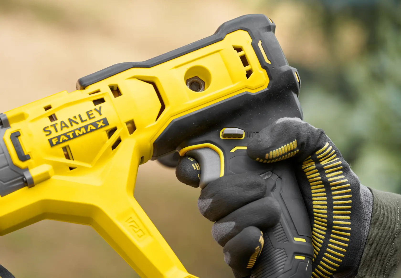 STANLEY SFMCGA75M1 FATMAX yellow and black power tool, close-up of handle, photography.