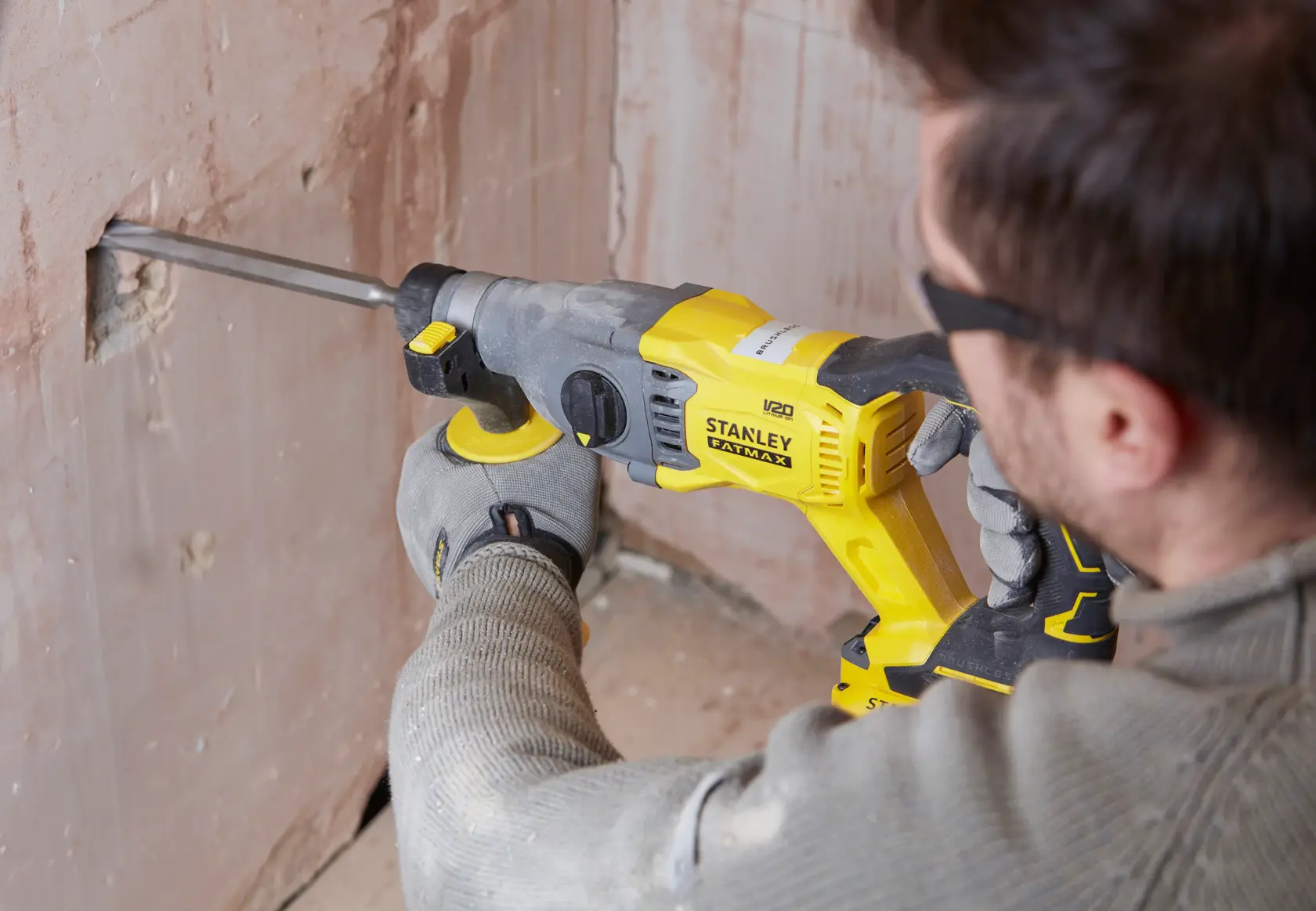 Foto einer Person, die einen STANLEY SFMCH900B Bohrhammer an einer Wand benutzt.
