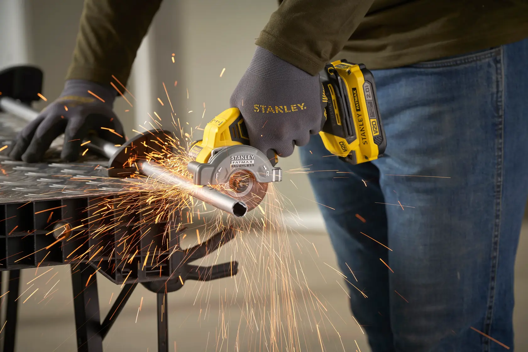 STANLEY SFMCM300B kompakter kabelloser Metallschneider im Einsatz, schneidet Metallrohr, Nahaufnahme mit Funken.