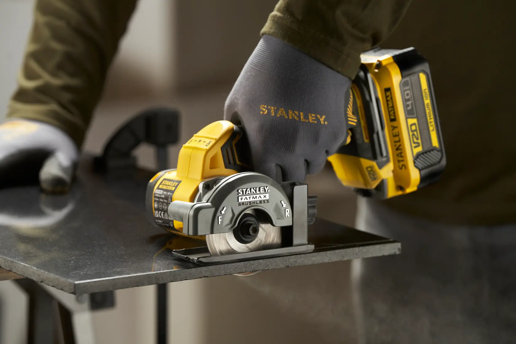 STANLEY SFMCM300B kompakte Kreissäge im Einsatz, schneidet ein Metallblech, Nahaufnahme seitlich.