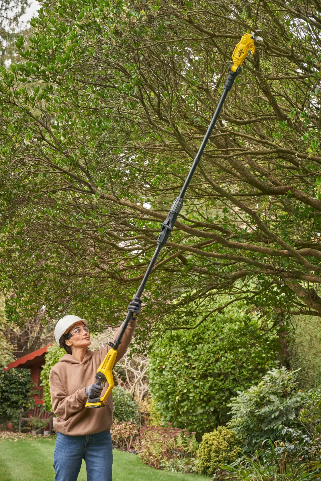 STANLEY SFMCPP632D1 Hochentaster im Außeneinsatz zum Baumschnitt, gelb-schwarzes Design, Fotografie.