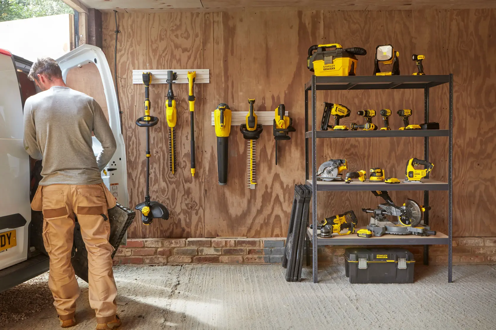 STANLEY SFMCPS620B Elektrowerkzeuge und Zubehör im Garagenregal und an Wandhalterungen organisiert.