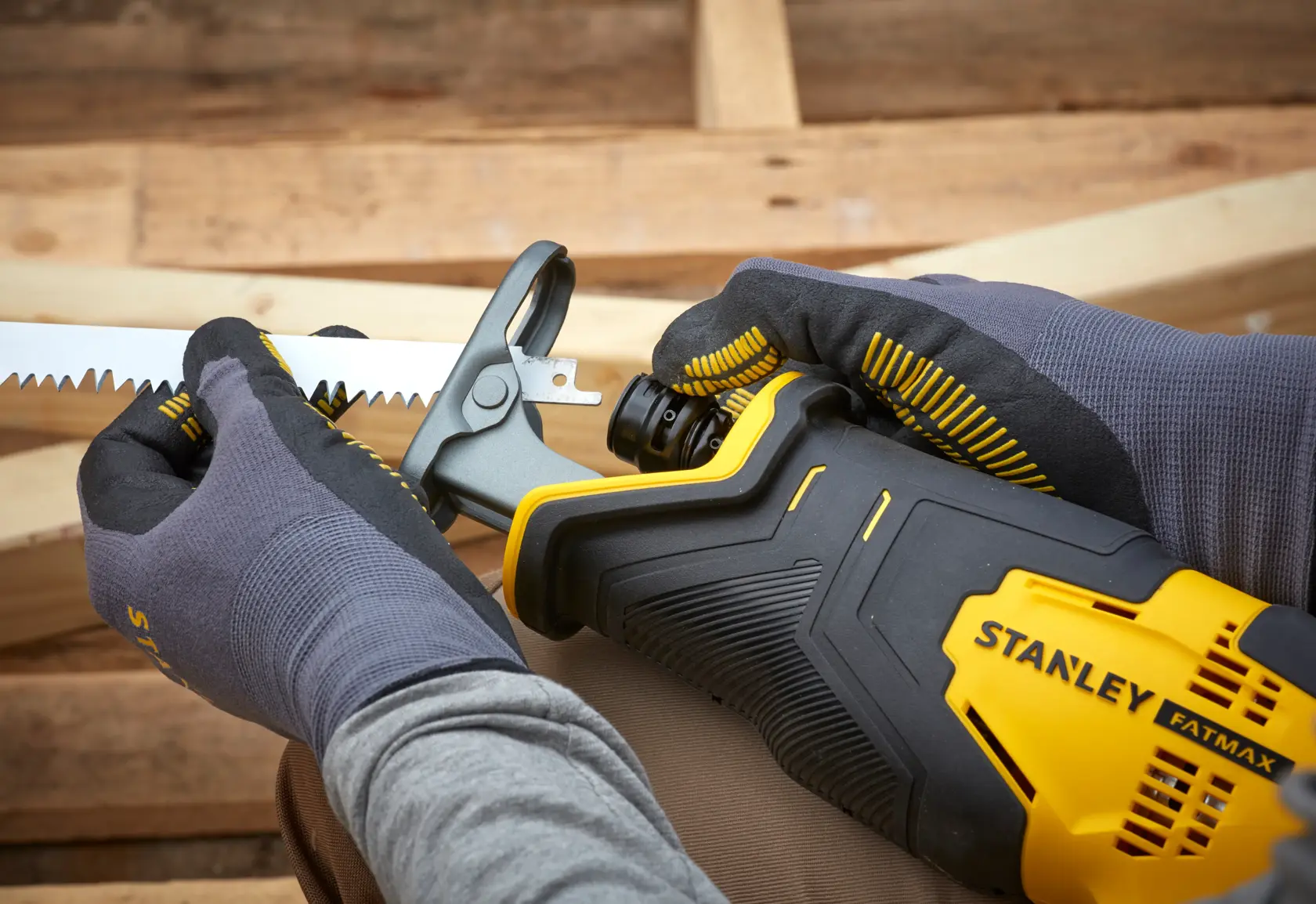 Photo of STANLEY SFMCS300D2K reciprocating saw being adjusted, close-up showing yellow and black tool.