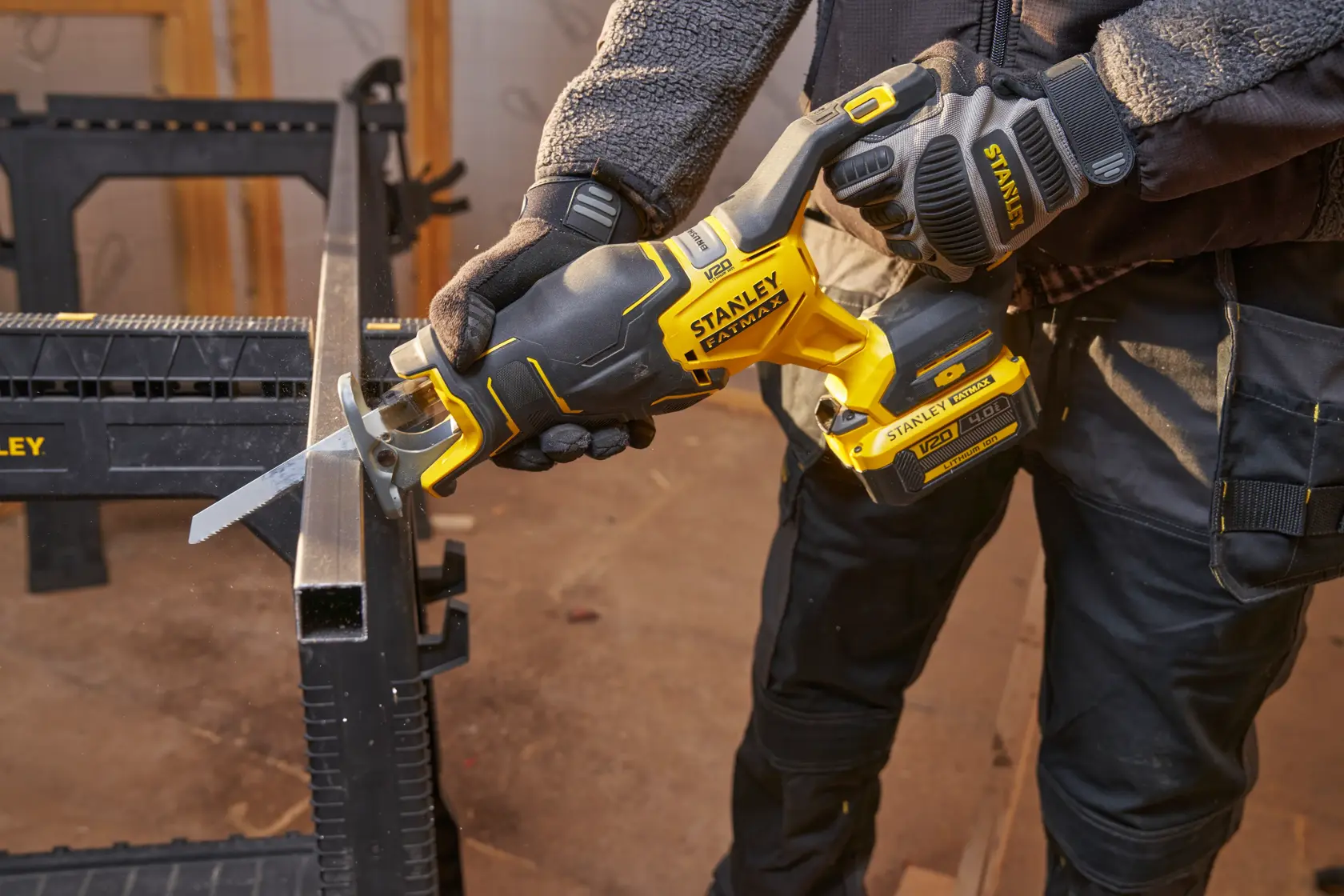 STANLEY SFMCS311B-XJ cordless reciprocating saw cutting metal, close-up of tool in use in workshop.