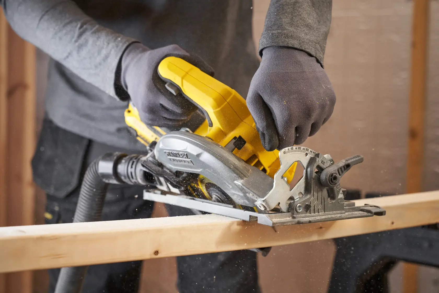 STANLEY SFMCS551B kabellose Kreissäge schneidet Holz, seitliche Aufnahme im Einsatz.