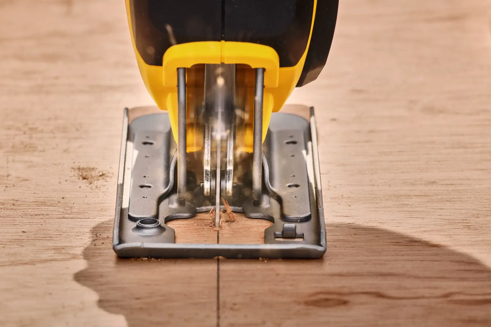 STANLEY SFMCS600M2K jigsaw cutting wood, close-up front angle, yellow and black tool, photography.