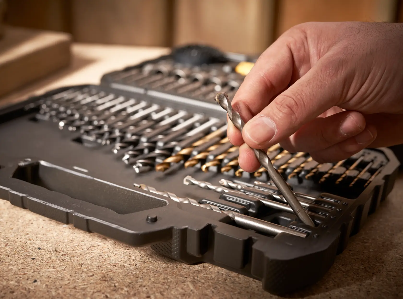 STANLEY STA88548 drill bit set in black case, close-up with hand selecting a silver drill bit, photography.