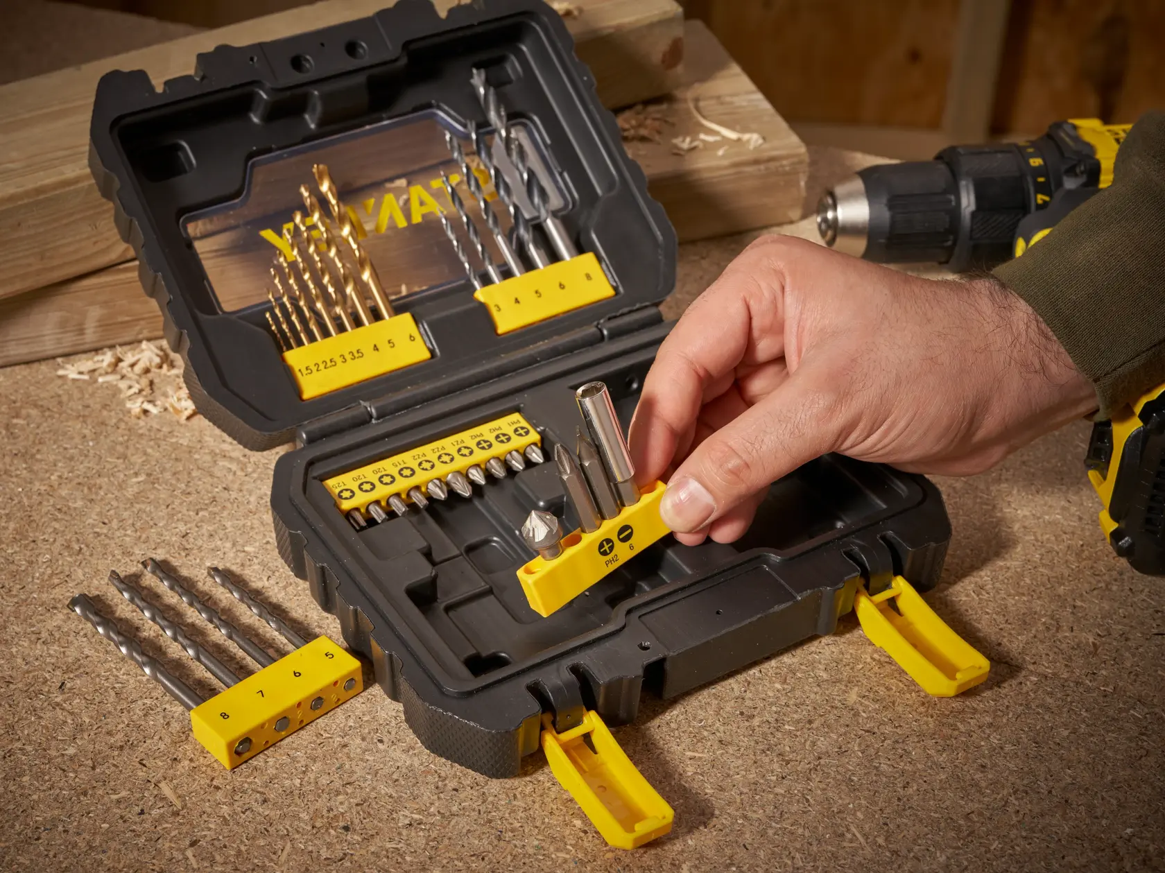 STANLEY STA88550 drill and bit set case on workbench, hand selecting bit holder, photo from above.