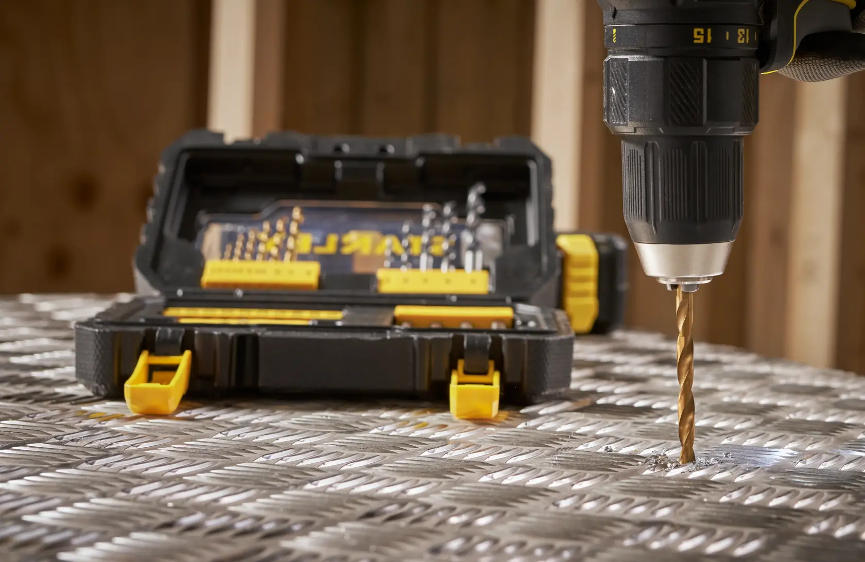 STANLEY STA88550 drill bit set in open black case with yellow latches, with drill bit in use on metal surface, front view.