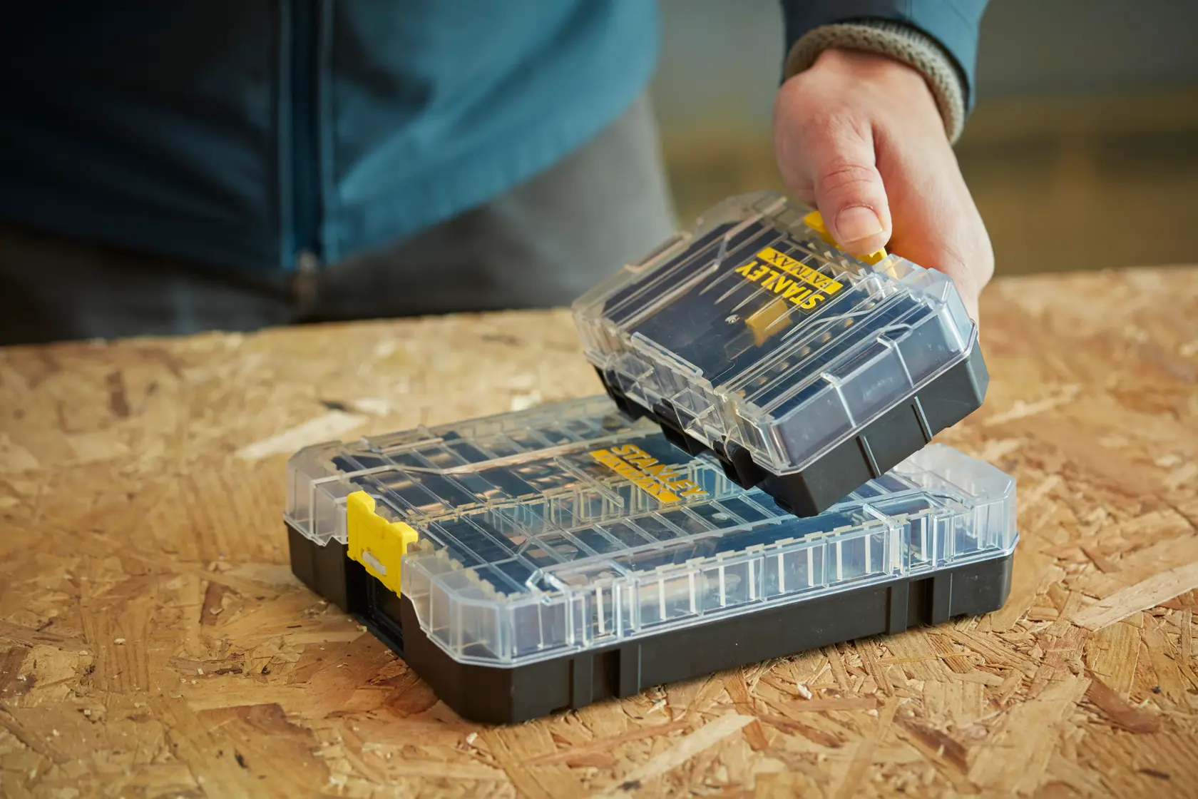 STANLEY STA88558 klar-schwarzer Organizer mit gelbem Verschluss, herausnehmbares Fach in der Hand.