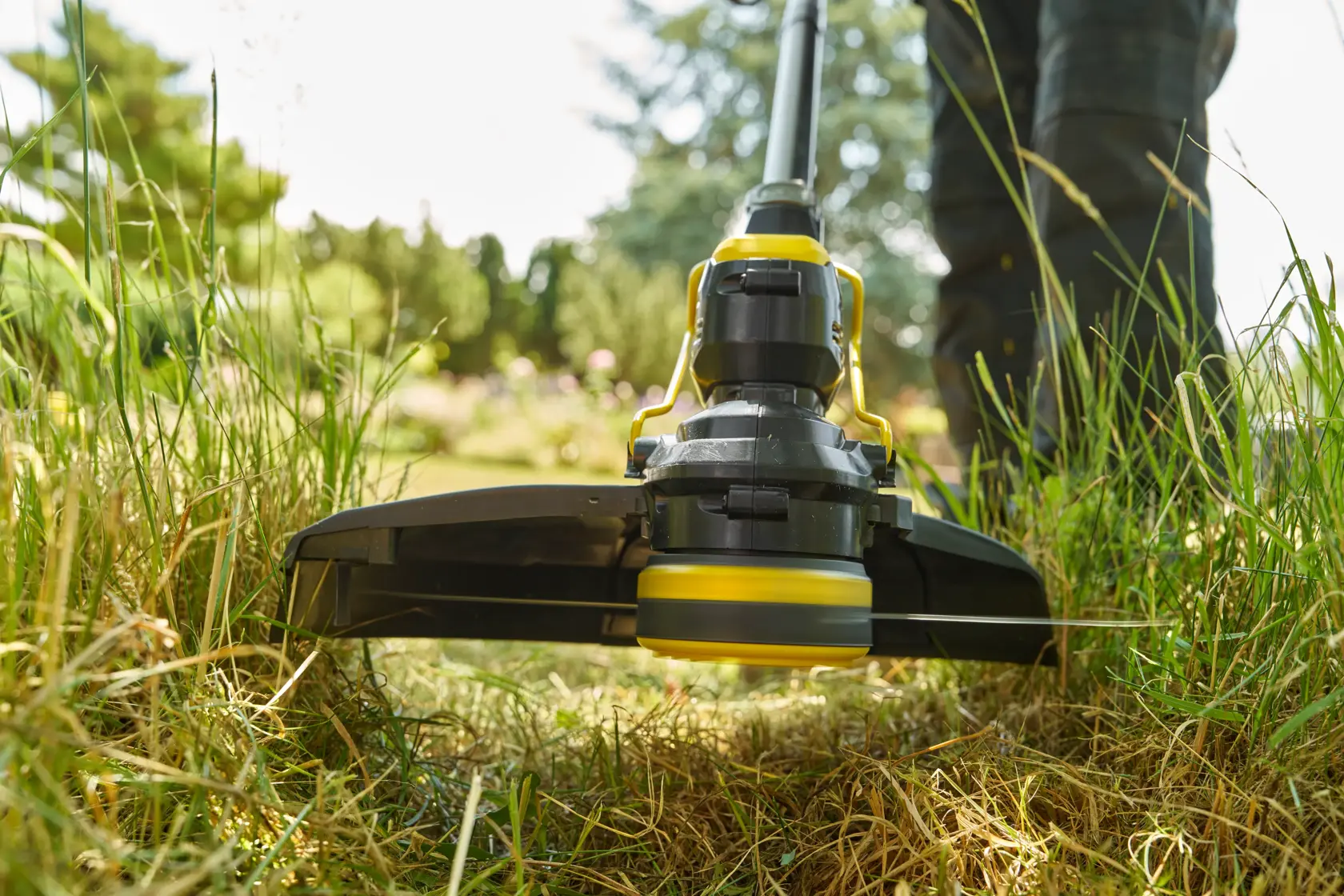 STANLEY STCST933M1 Rasentrimmer Nahaufnahme, im Einsatz auf Rasen mit grünem Gras, Foto im Freien.