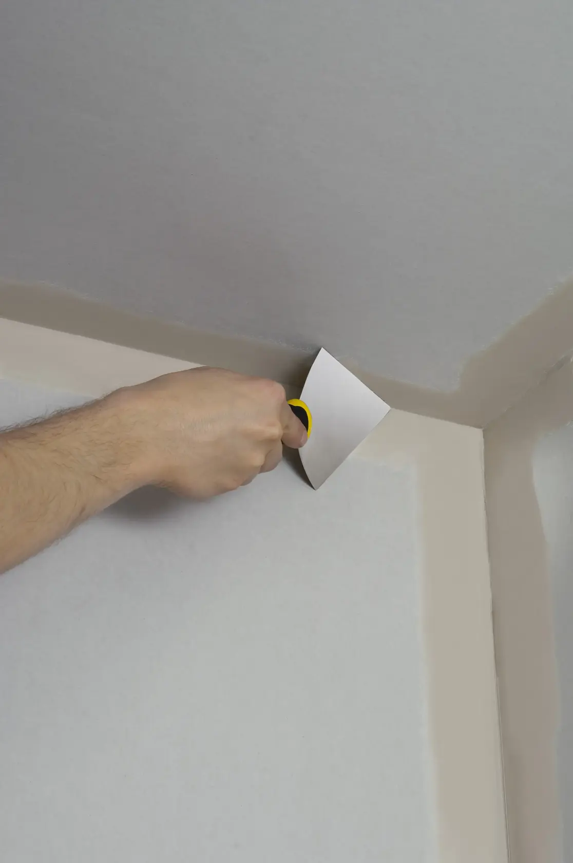 STANLEY STHT0-26089 Spachtel im Einsatz zum Verteilen von Spachtelmasse in einer Wand-Ecke.