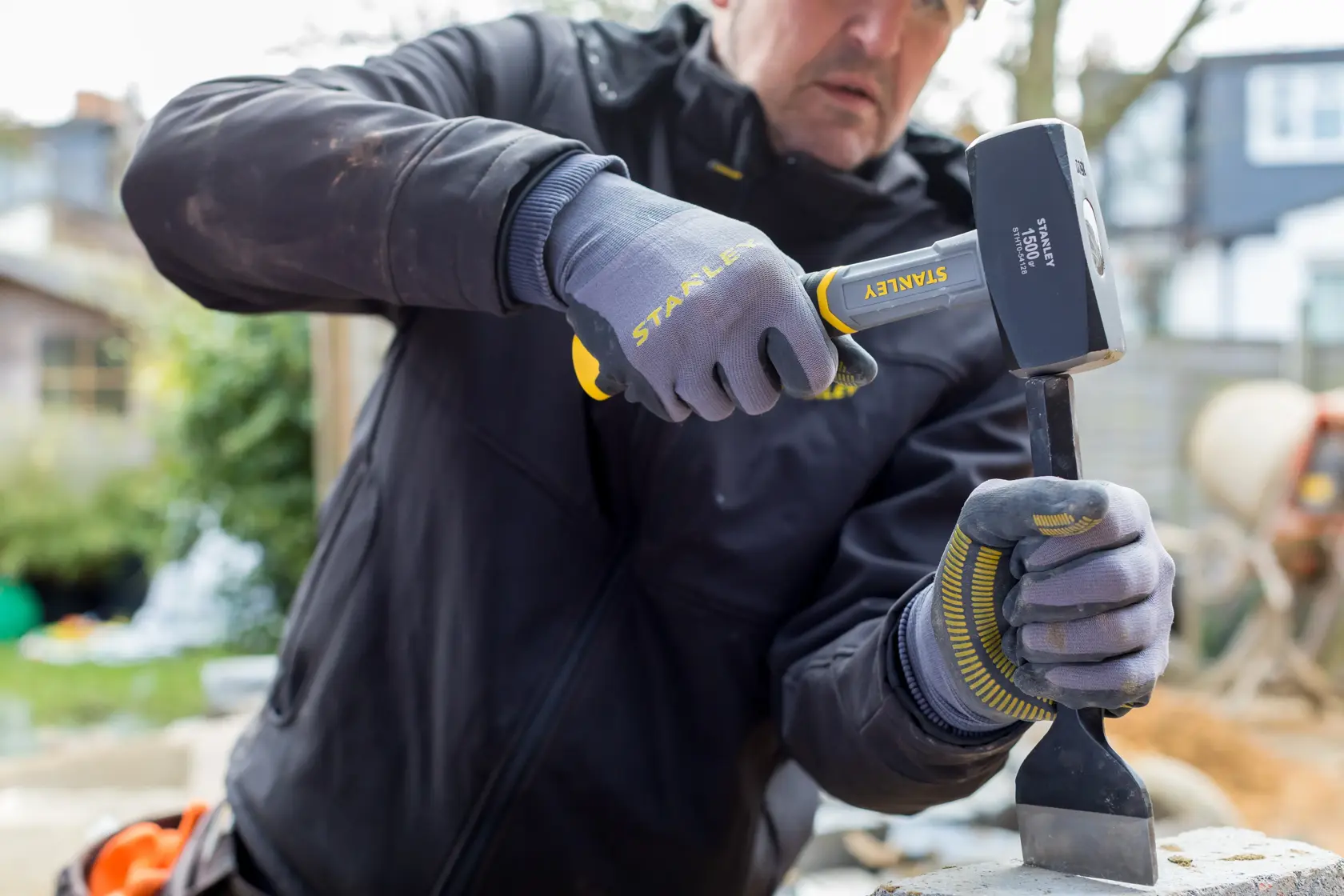 Foto des STANLEY STHT0-54128 Vorschlaghammers im Einsatz mit Handschuhen im Außenbereich.