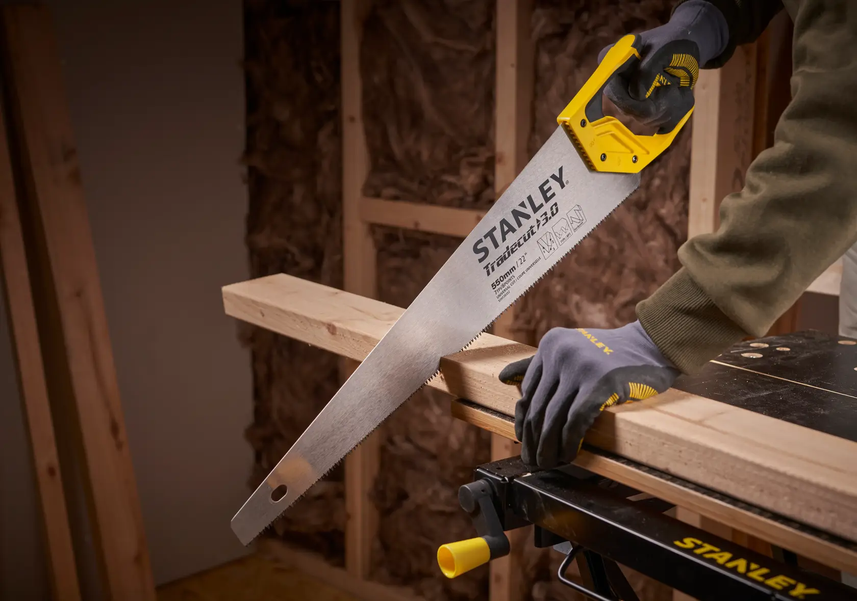 STANLEY STHT1-20352 Handsäge mit gelbem Griff schneidet Holzträger in Werkstatt.