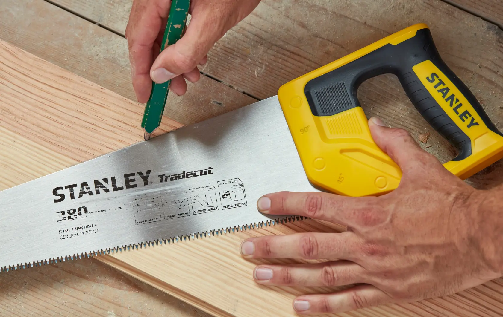 STANLEY STHT20348-1 Handsäge mit gelbem Griff auf Holz, Nahaufnahme der Schneidzähne und Markendetails.