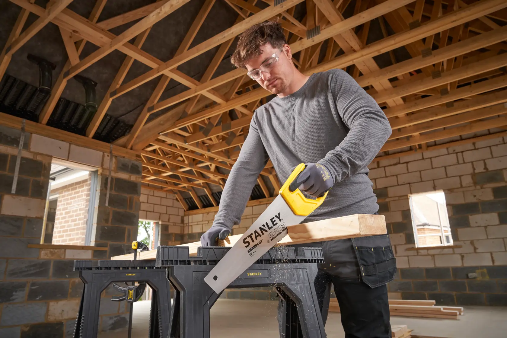 STANLEY STHT20366-1 Handsäge schneidet Holz auf Sägebock, Innenbaustelle.