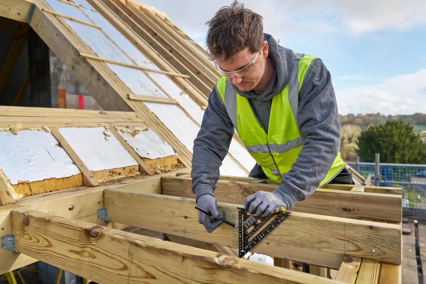 STANLEY STHT46101-0 square used to mark wooden beams on a rooftop construction site.