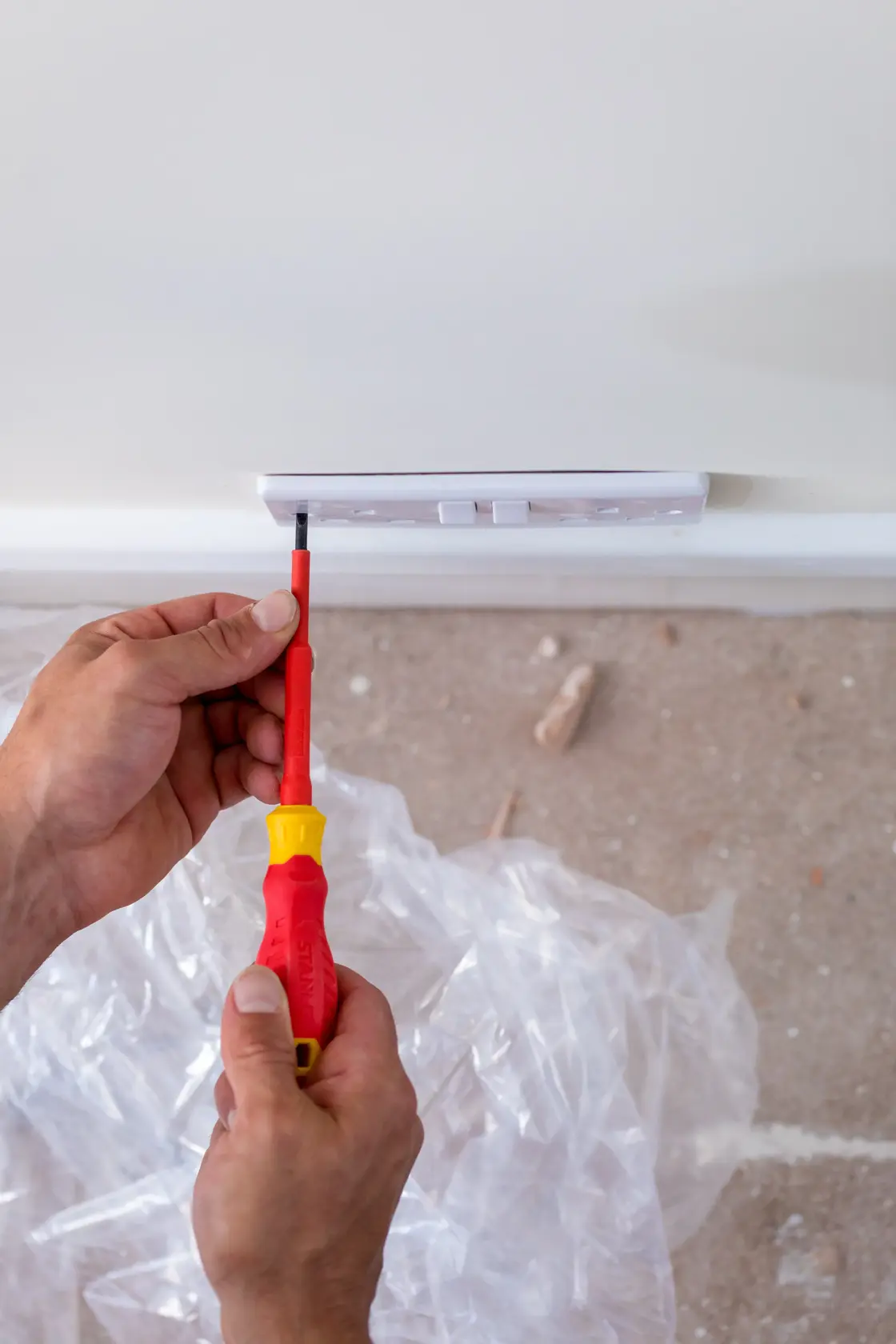 Photo of STANLEY STHT60030-0 insulated screwdriver used to install a wall outlet, close-up view.