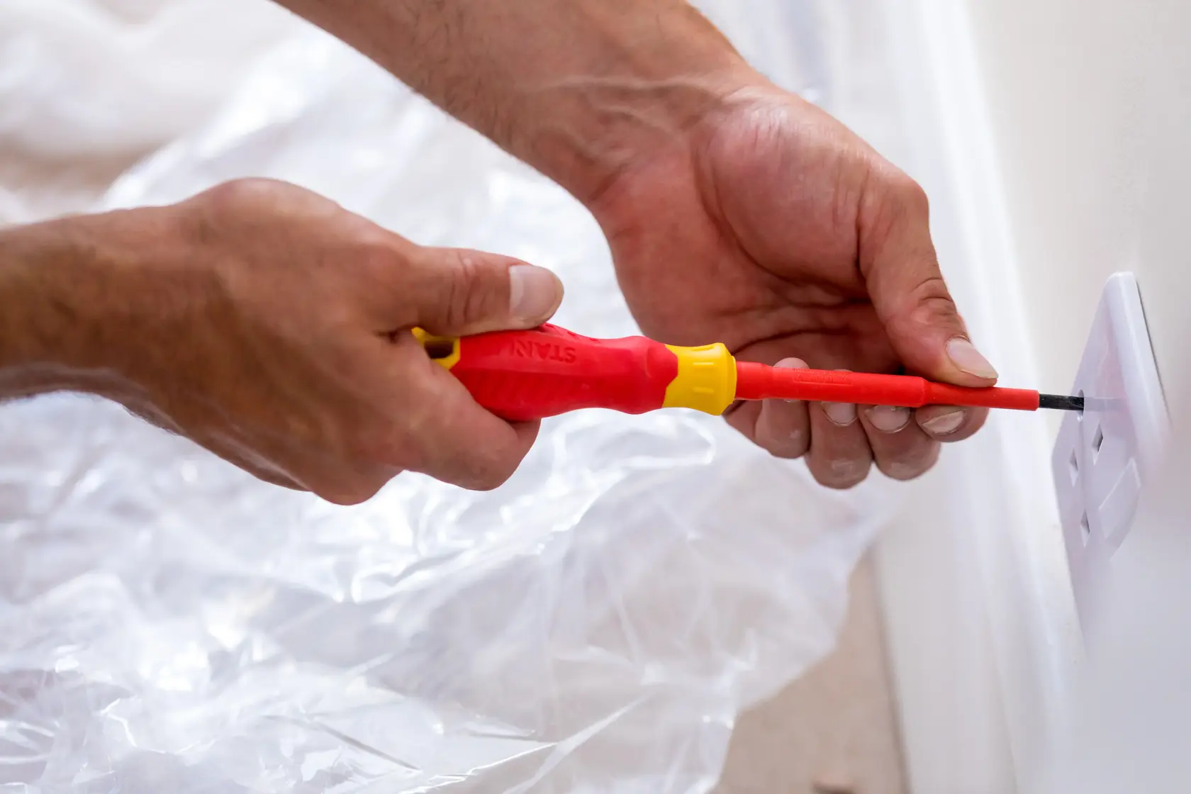 Photo of STANLEY STHT60030-0 insulated screwdriver in use installing a socket cover.