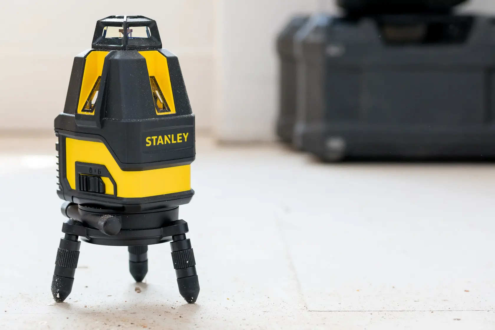 STANLEY STHT77524-1 Laser-Nivelliergerät auf Stativ, gelb und schwarz, Innenbereich, Produktfotografie.