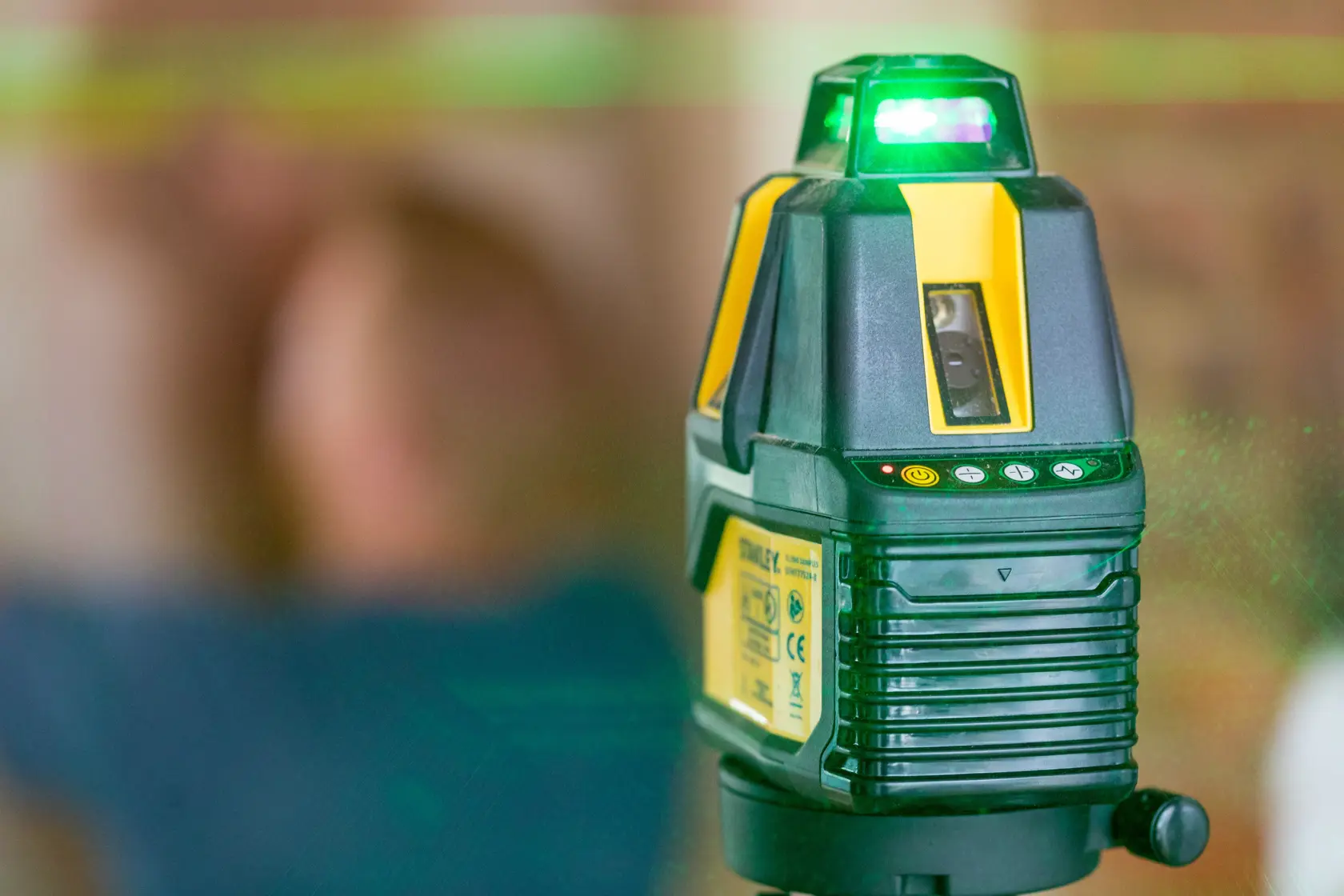 STANLEY STHT77524-1 Laser-Nivelliergerät mit grünem Laserstrahl, Innenaufnahme als Nahaufnahme.