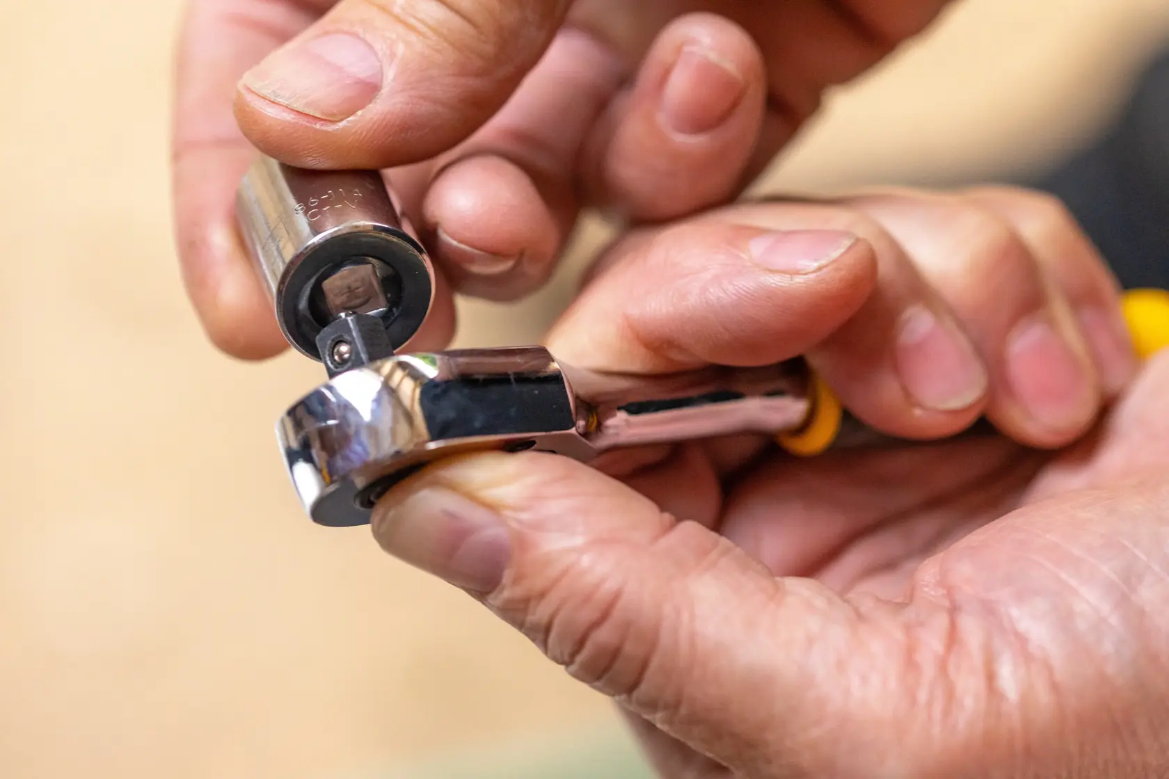 STANLEY STMT82663-0 Ratschen-Schlüssel mit Stecknuss in der Hand gehalten, Nahaufnahme.
