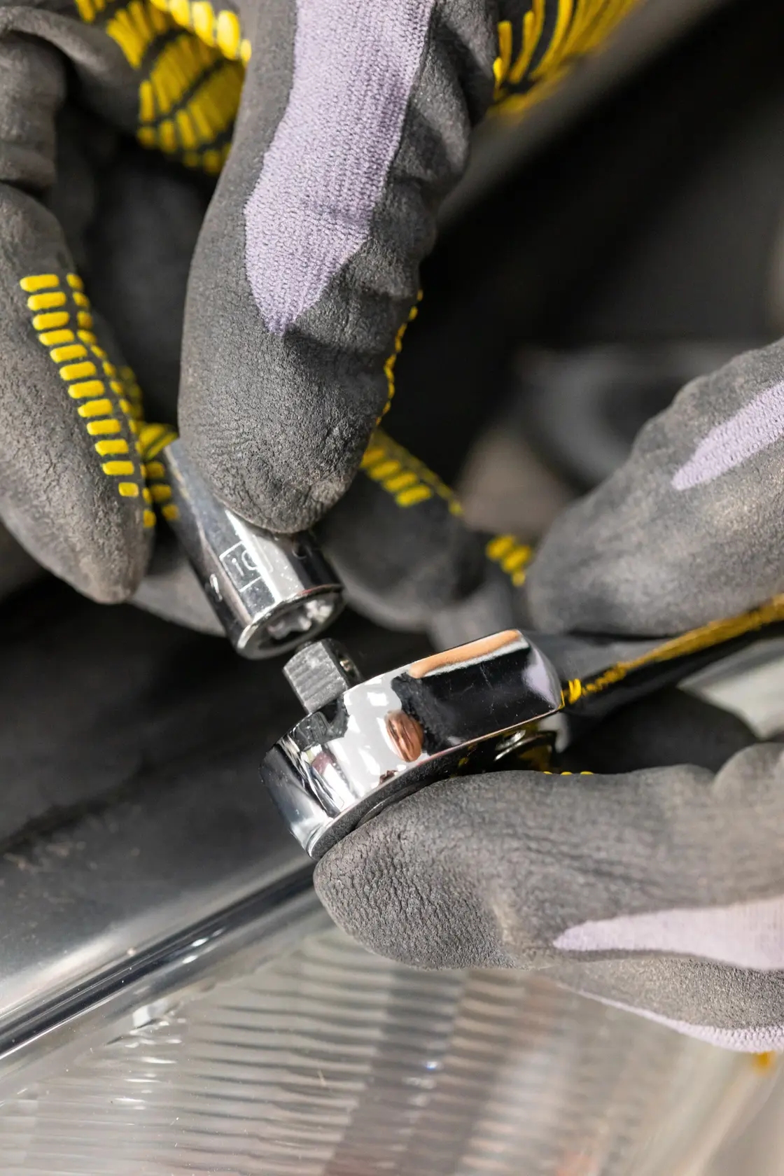 STANLEY STMT86103-0 Fotografie einer behandschuhten Hand, die eine Stecknuss auf einen Chrom-Ratschen-Schlüssel setzt.