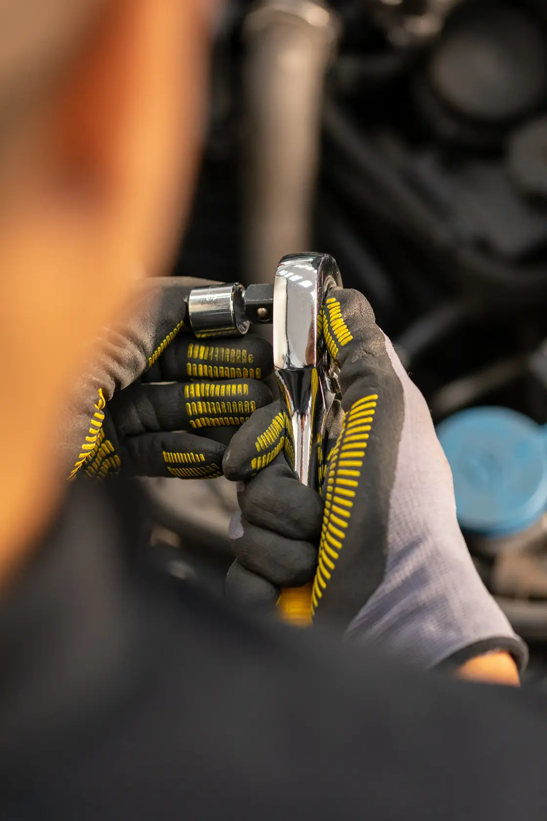 STANLEY STMT86517-0 Ratschen-Schlüssel in behandschuhte Händen, Nahaufnahme bei Mechanikarbeiten.