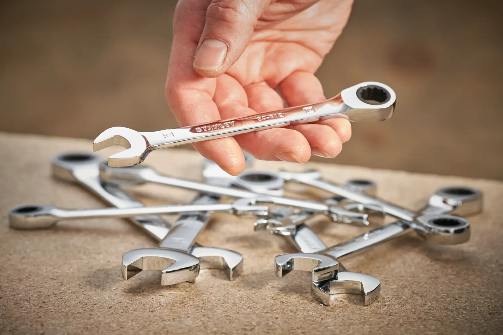 STANLEY STMT89911-0 ratcheting spanner set shown on a workbench, one spanner held in hand.