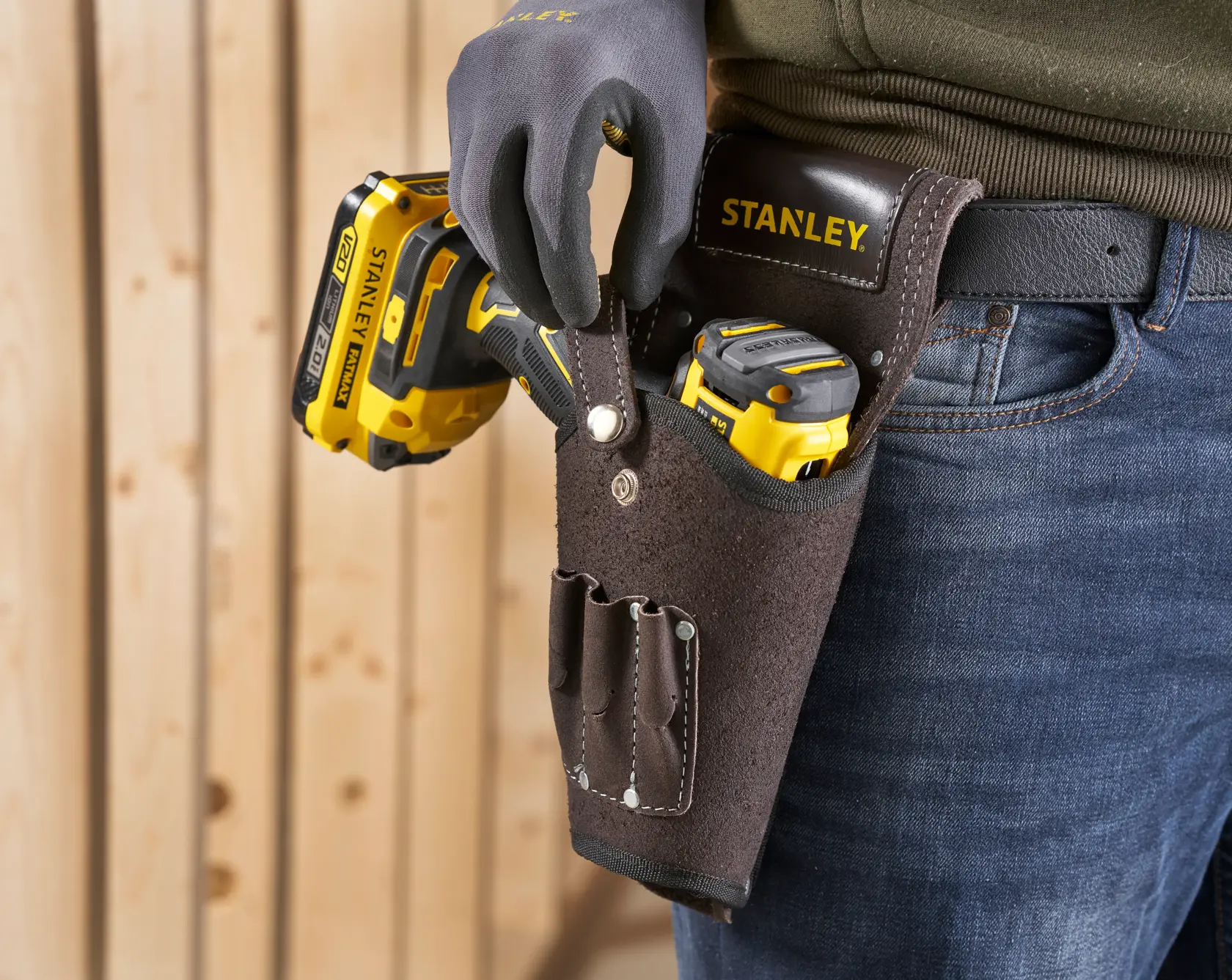 STANLEY STST1-80118 Lederwerkzeugholster am Gürtel, mit gelben Elektrowerkzeugen, Nahaufnahme.