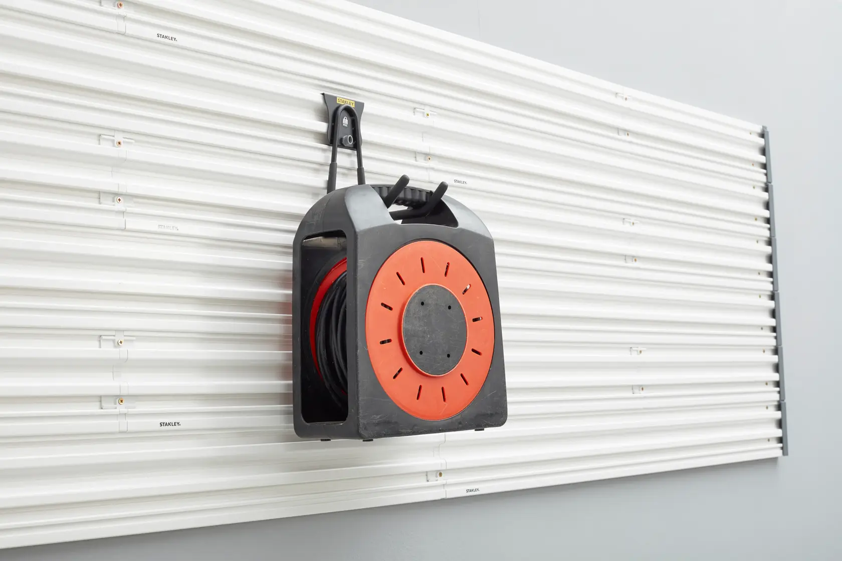 STANLEY STST82608-1 Wand-Kabelaufroller, schwarz und orange, Foto aus Frontalansicht.