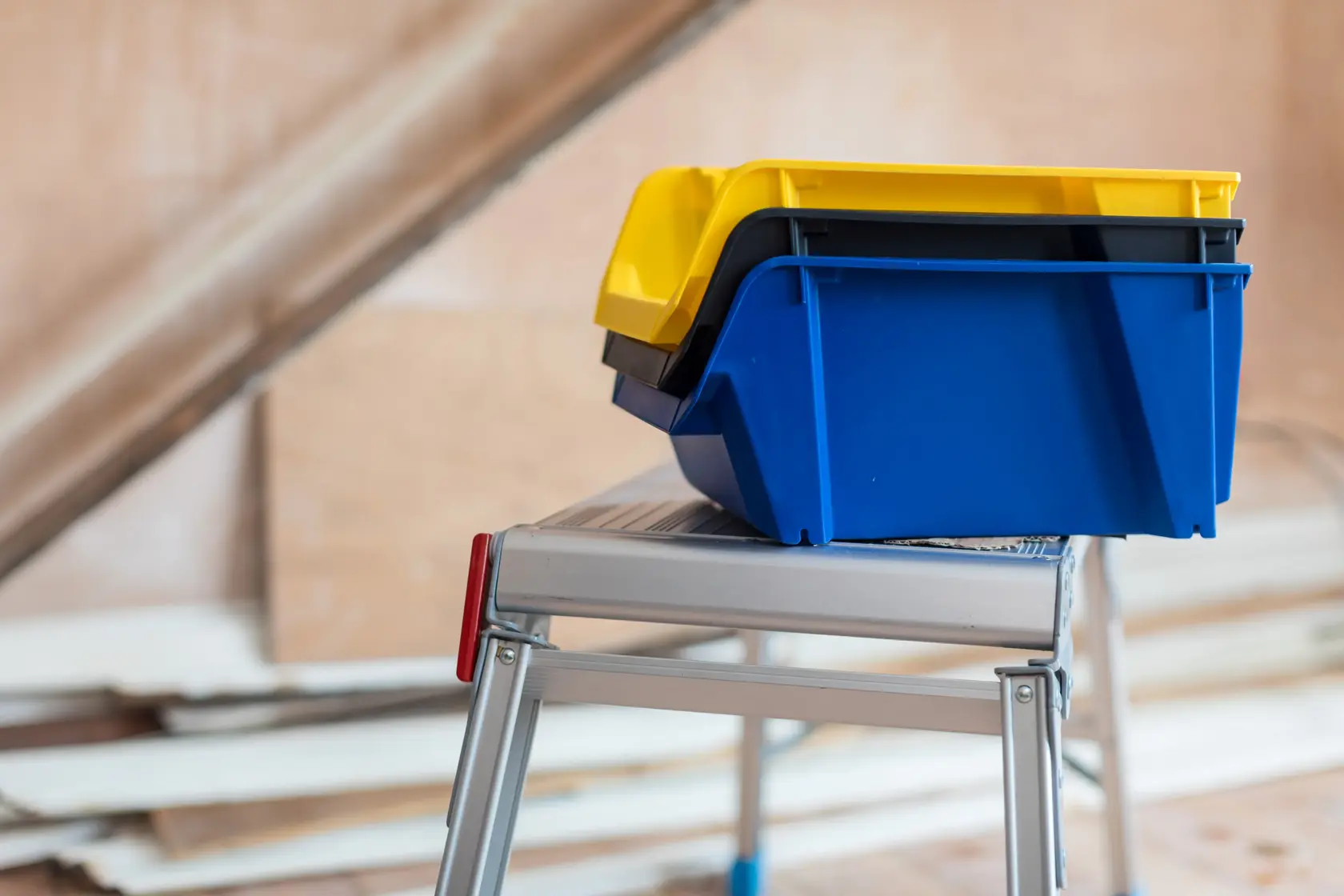 STANLEY STST82743-1 stapelbare gelbe und blaue Aufbewahrungsboxen auf Metall-Trittleiter Seitenansicht.