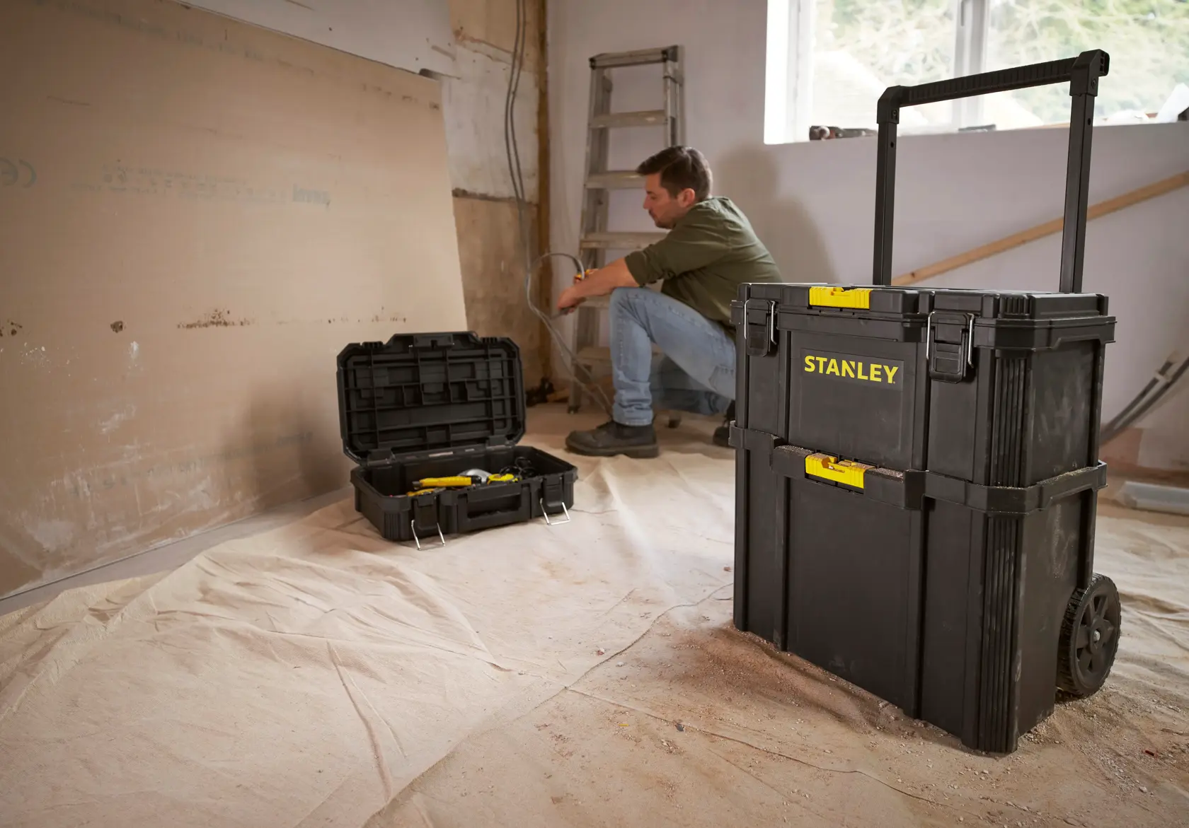 STANLEY STST83319-1 rollender Werkzeugkasten im Werkstattbereich, offene Werkzeugbox im Hintergrund.