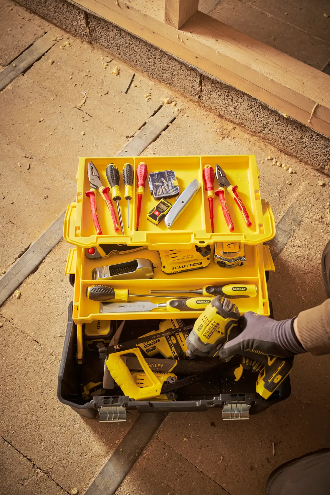 Stanley STST83397-1 Werkzeugkasten mit verschiedenen Handwerkzeugen, gelbem Fach und Elektrowerkzeug, Draufsicht.