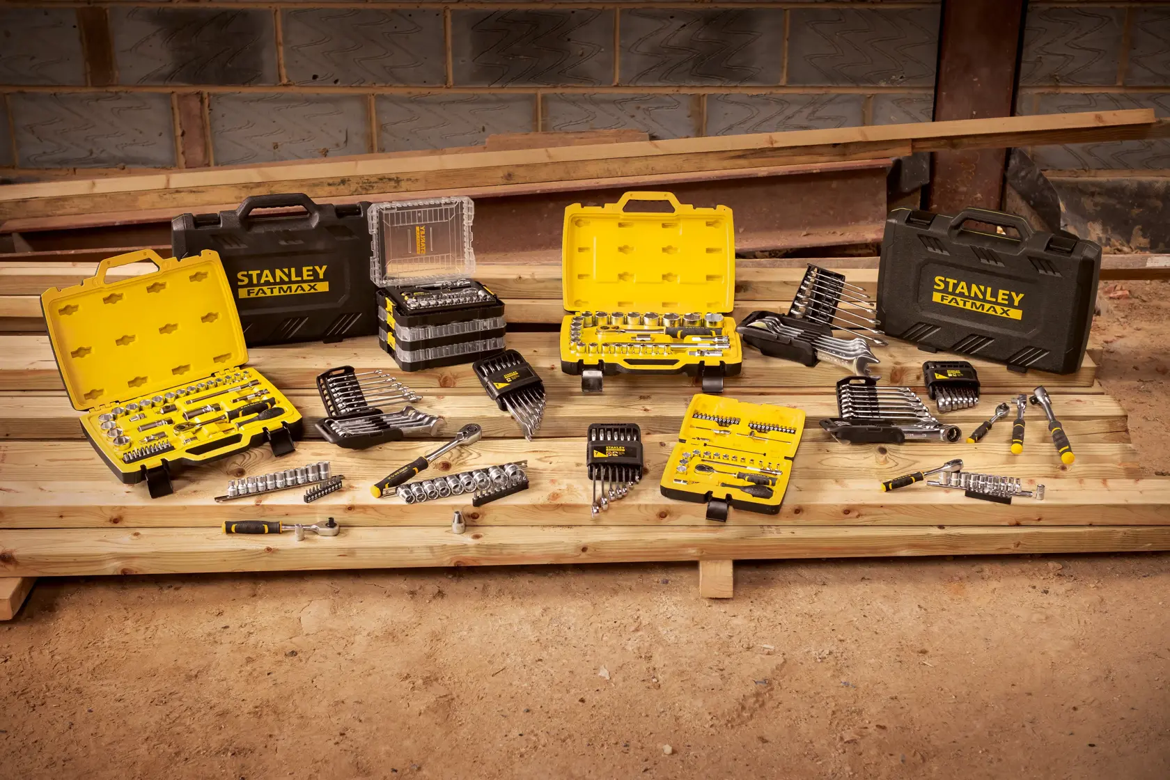 STANLEY STMT82663-0 Werkzeugsätze und Koffer auf Holzplanken in einer Werkstatt.